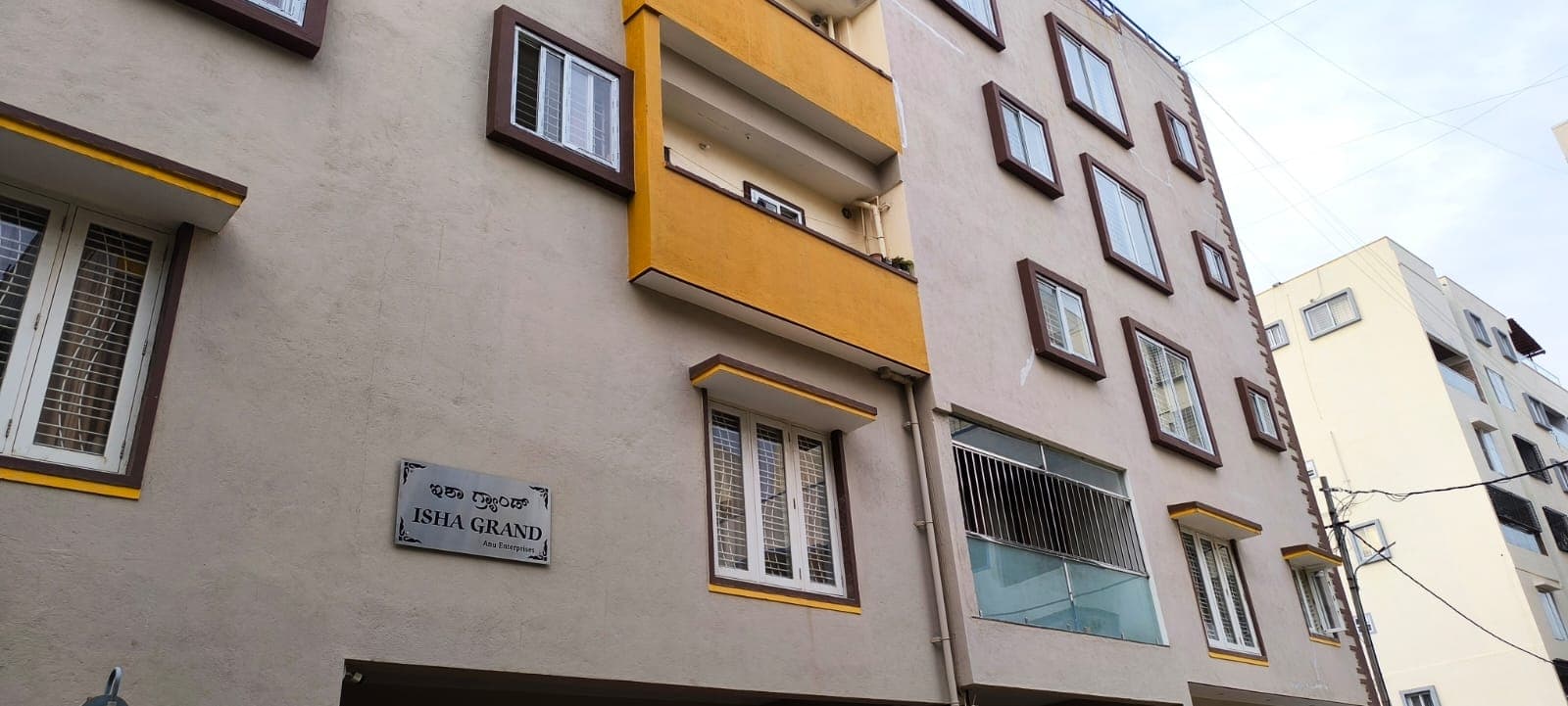 Isha Grand apartment building facade with its name plate