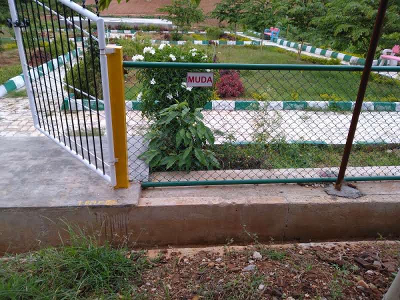 Landscaped park behind the MUDA-marked gate